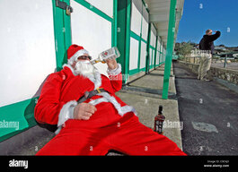 drunk-santa-claus-at-langland-bay-near-swansea-while-a-surfer-checks-C9CAJ3.jpg